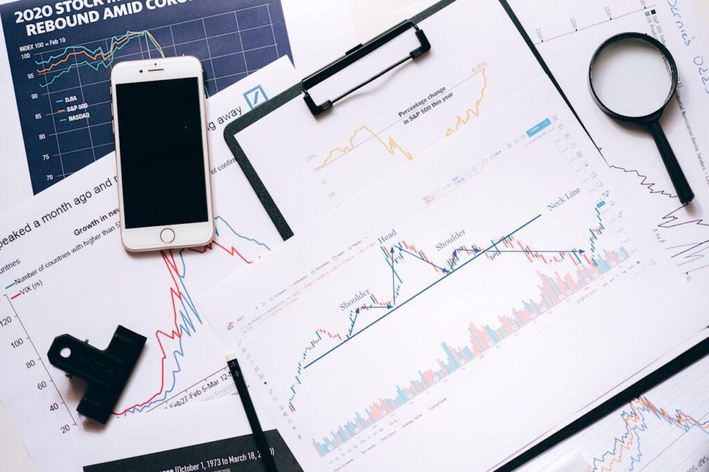 The Art of Drawing Readers In: Your attractive post title goes here Stock market analysis setup with charts, phone, magnifier, and clipboards.